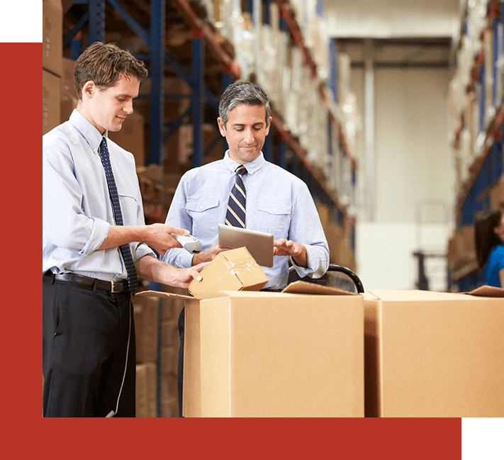 Two men in a warehouse with boxes on the floor.