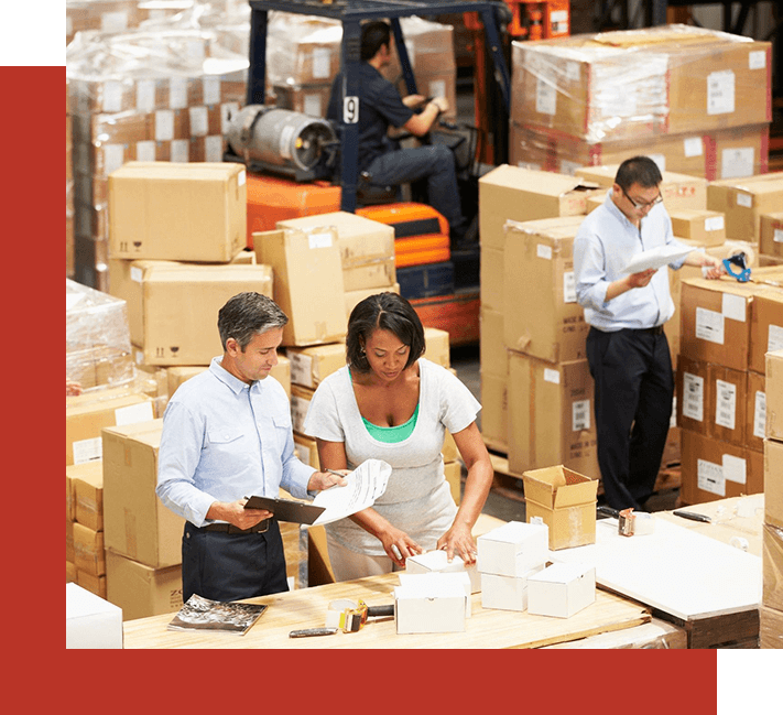 A group of people standing around boxes in a warehouse.